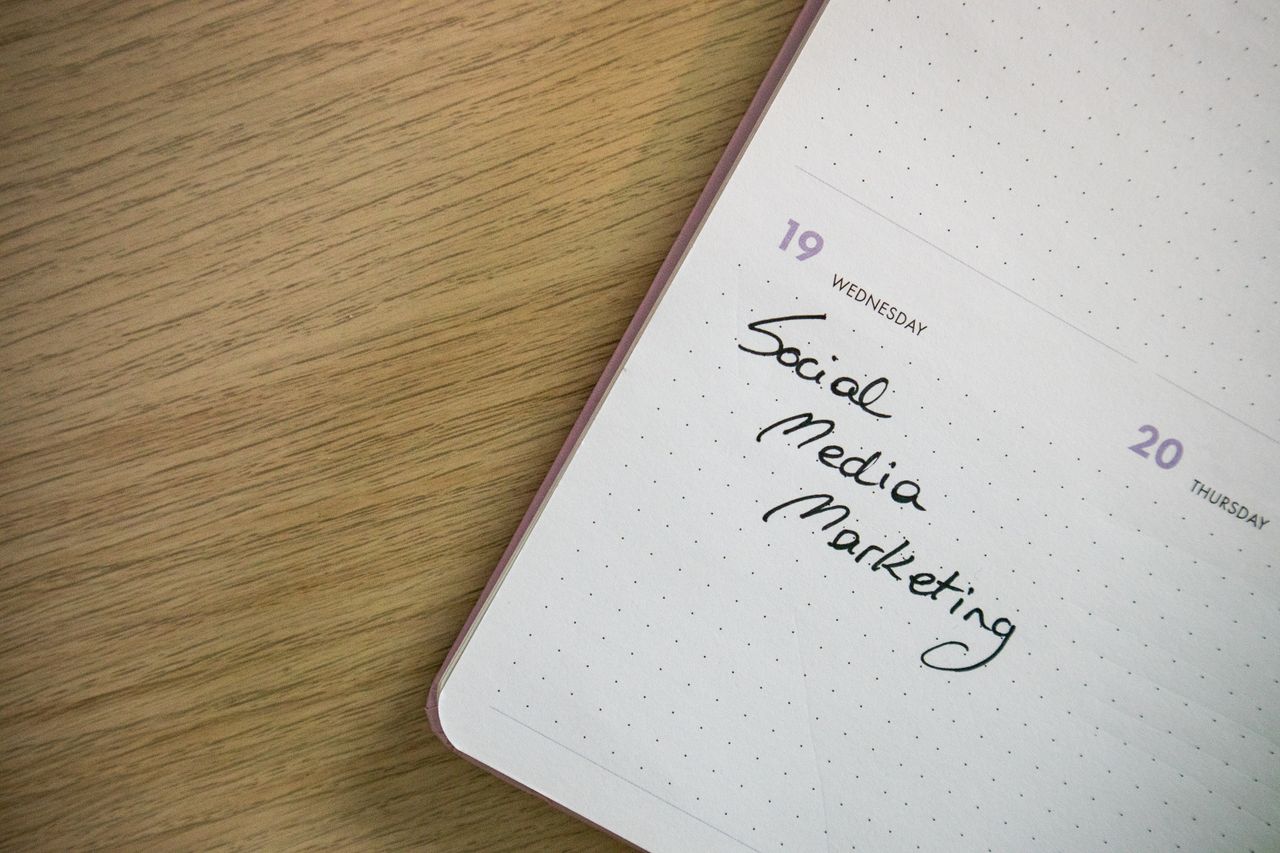 Gros plan sur une page de carnet avec l’inscription Social Media Marketing manuscrite.